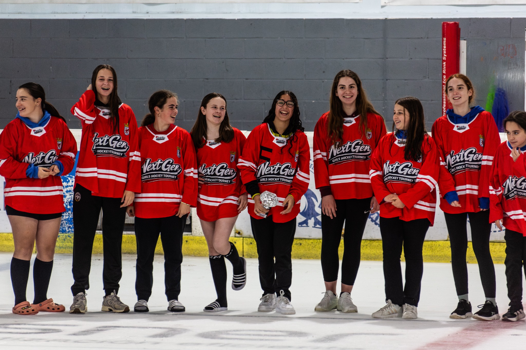 Next Gen players together in red team jerseys at the rink