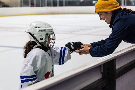 Leyre Villar coaching a young hockey player