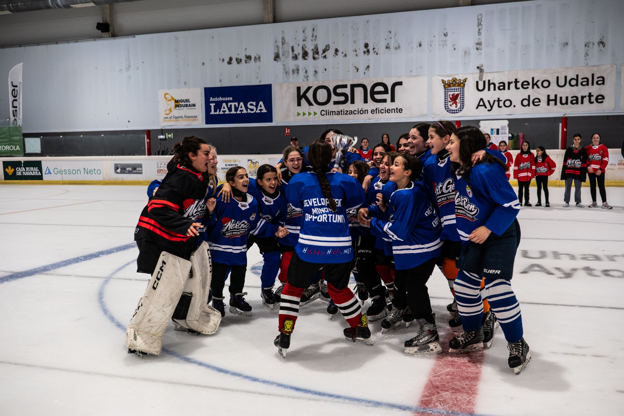 Next Generation Girls Hockey players celebrating together on the ice